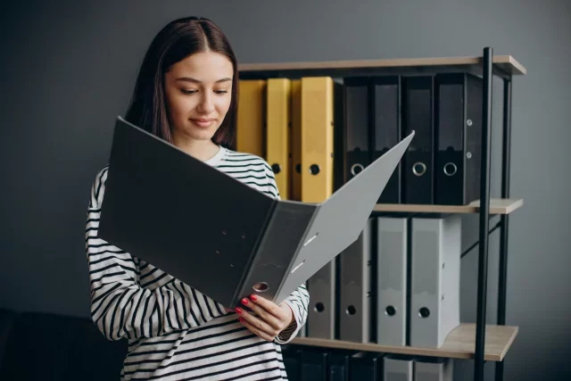 mulher em um arquivo com uma pasta de documentos nas mãos, guarda de documentos